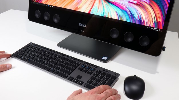 Dell XPS 27 con teclado y mouse en la mano