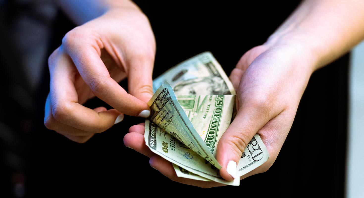 Mujer contando dinero con los dedos